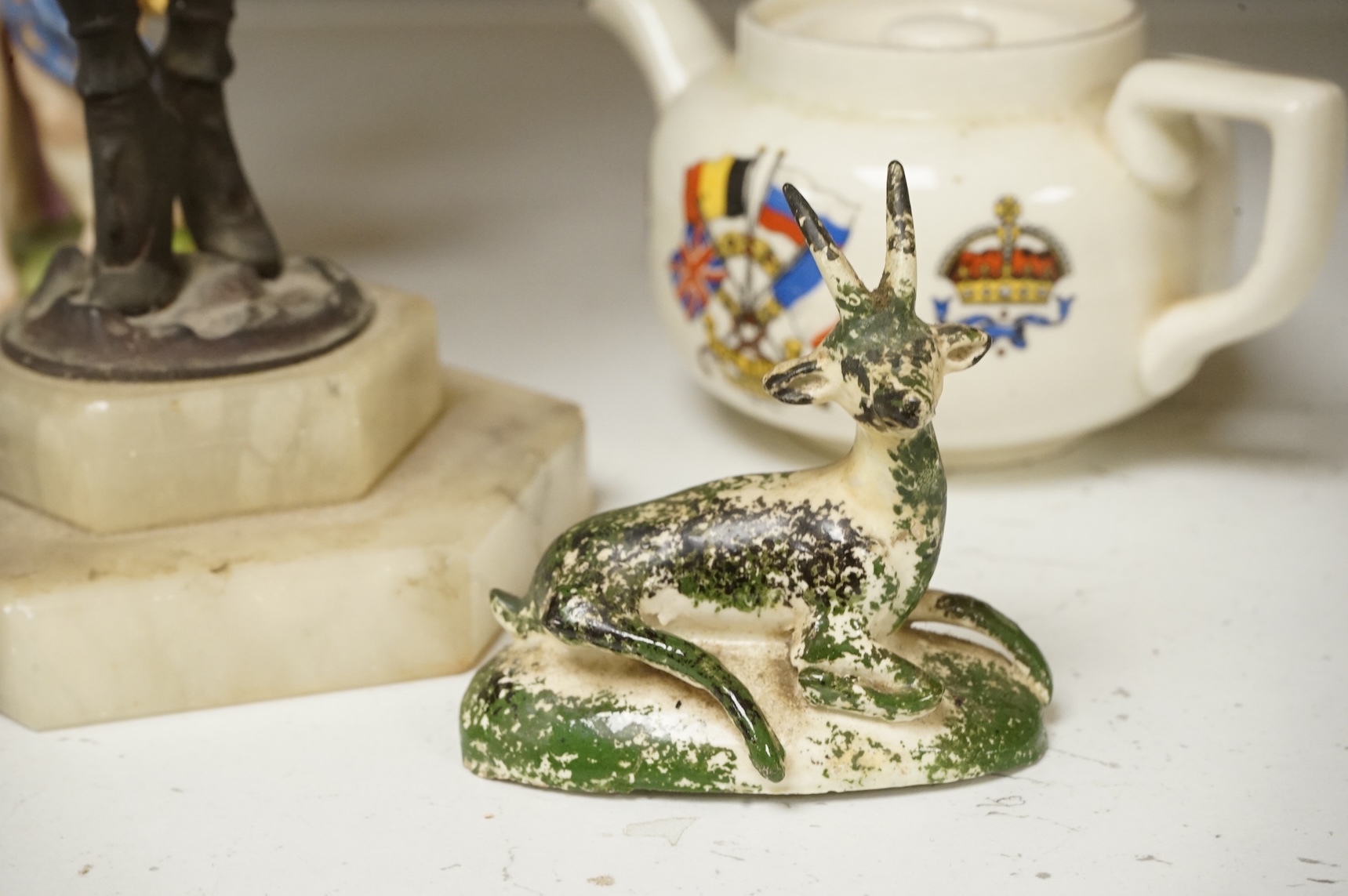 An Art Deco resin and patinated spelter model of a dancer on onyx base, two late 18th century Staffordshire coloured creamware recumbent cows and a spongeware deer, a WWI commemorative teapot with ‘For Right and Freedom’